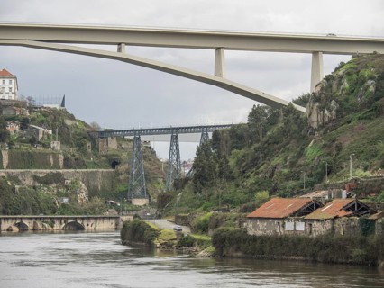 Two bridges over a valley with a river and surrounding nature under a cloudy sky, Porto, Douro,
