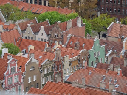 Panorama of colourful gabled houses in an old town with orange roofs and green courtyards, Gdansk,