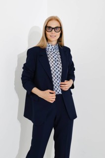 Studio portrait of a modern confident woman in a navy blue classic fitted suit