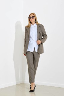 A full-length portrait of a professional woman in checkered suit walking confidently in a modern
