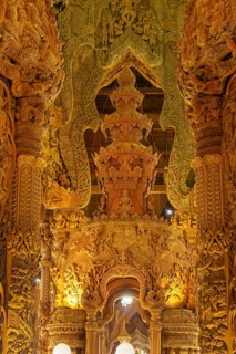 Interior view of an ornately carved wooden temple with magnificent golden elements, Pattaya,