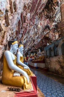 Religious carvings on limestone rock and colourful Buddha statues