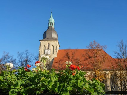 Church tower and blooming flowers, autumn leaves and blue sky, peaceful atmosphere, nottuln,