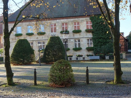 Historic building, surrounded by trees and bushes in autumn foliage, peaceful atmosphere on