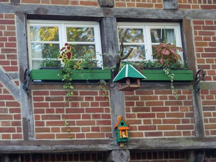 Flower-decorated windows of a half-timbered house with decorative birdhouses, nottuln, münsterland,