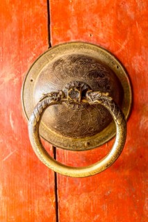 Golden door knob on a red wooden door