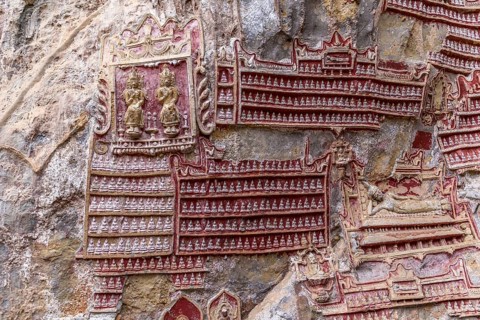 Hundreds of tiny Buddha Statues on limestone rock