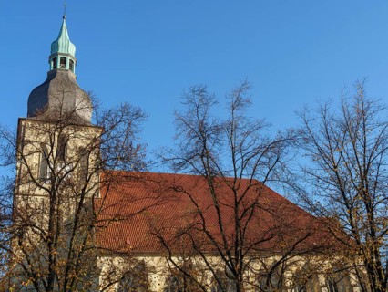 Church tower with clock and red roof tiles, surrounded by autumnal trees, nottuln, münsterland,