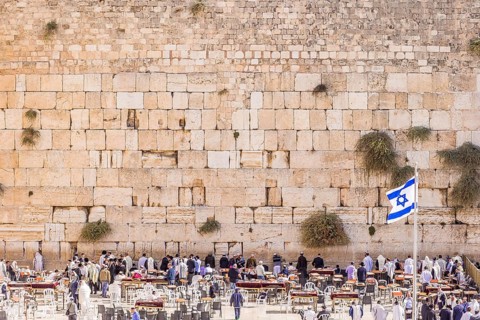 The Western wall in Jerusalem with state flag of Israel