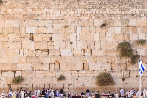 The Western wall in Jerusalem with state flag of Israel