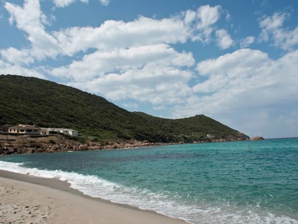 A wide sandy beach with gentle waves, surrounding hills and a loose woollen sky, ajaccio, corsica,