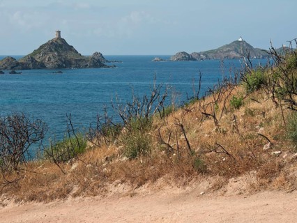 View of two islands in the sea, surrounded by barren hills and withered vegetation in the