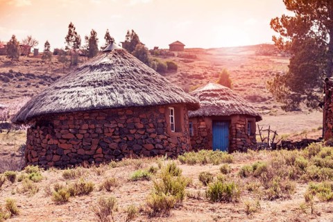 Huts with blue door in Sunset Lesotho