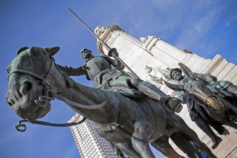 The Cervantes Monument at the Plaza de Espana in Madrid depicts a stone statue of the historic