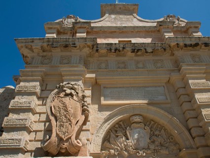 An elaborately decorated Tor tor of an old fortress with stone coats of arms and arches, all made