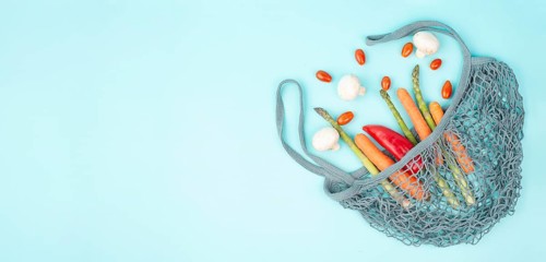 Asparagus sprout, mushrooms, carrots and tomatoes, zero waste, mesh bag with vegetables, shopping