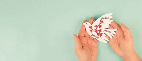 Dove with hearts flying from hand, international peace day, faith, freedom, charity and help