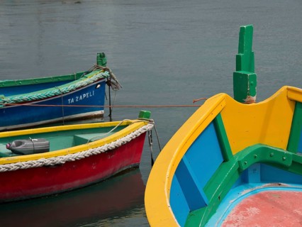 Multicoloured boats with bold colours docked in the water, marsaxlokk, mediterranean sea, malta