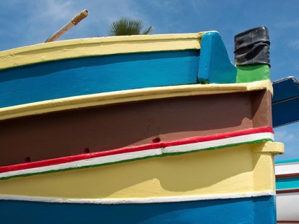 Multicoloured boat from the side with blue sky in the background, marsaxlokk, mediterranean sea,