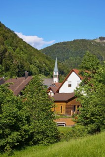 Black Forest landscape with hills, houses and the church of St Wendelin in the district of