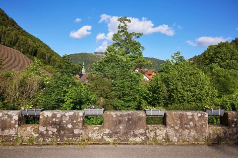 Old bridge with stone wall and flower boxes in the historic district of Geschwend, Todtnau, Black