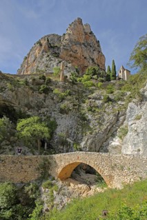 Stone arch bridge over the Ravin de Notre Dame stream and Notre-Dame de Beauvoir church, rock,