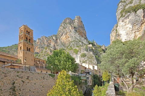 Church tower of Notre-Dame-de-l'Assomption and view to the rock, cliffs, summit, mountains,