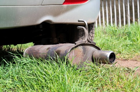 Broken exhaust and muffler of a car, rusted silencer fallen down on the road, breakdown of vehicle