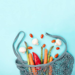 Asparagus sprout, mushrooms, carrots and tomatoes, zero waste, mesh bag with vegetables, shopping