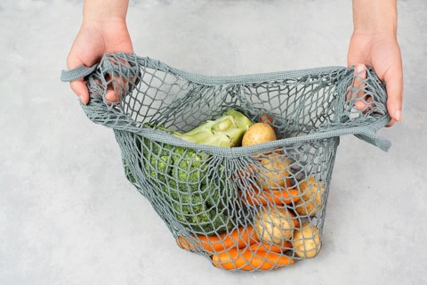 Mesh bag with vegetables, shopping grocery, healthy food ingredients, potato, broccoli and carrots,