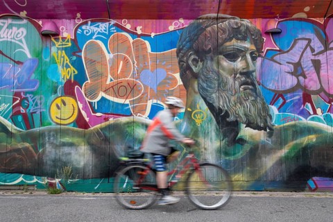 God of Greek mythology, Zeus, large graffiti on building fence, cyclist, harbour, Gothenburg,