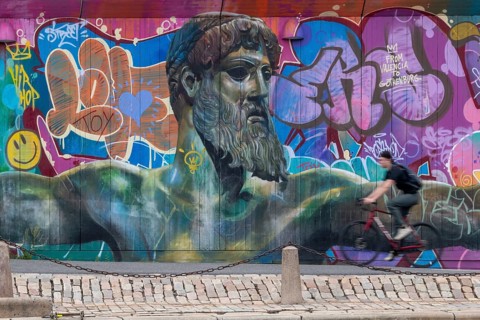 God of Greek mythology, Zeus, large graffiti on building fence, cyclist, harbour, Gothenburg,