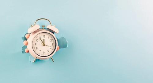 Hand holding alarm clock, torn paper hole, time management, reminder and planning, finish a
