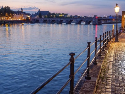 Evening riverside promenade with river and illuminated street lamp and reflective lights,