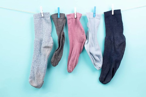 Lost socks hanging on a clothes line with clothespin, missing sock match after washing, memorial