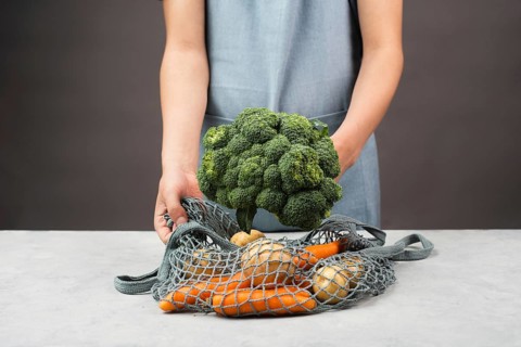 Mesh bag with vegetables, shopping grocery, healthy food ingredients, potato, broccoli and carrots,