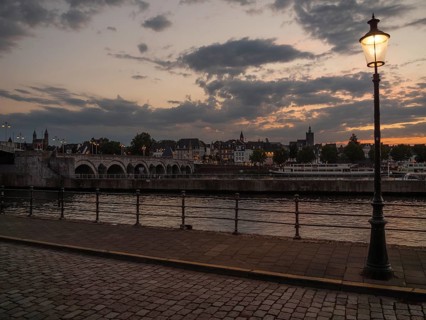 Riverbank at dusk with a street lamp and a cobblestone walkway, Maastricht, limburg, the