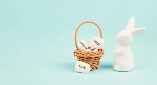 Easter bunny or rabbit with wicker basket, words like love, luck, joy and courage are standing on