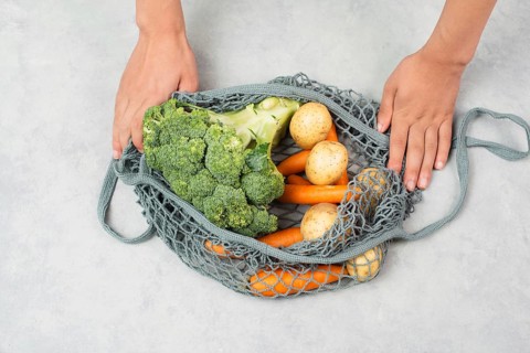 Mesh bag with vegetables, shopping grocery, healthy food ingredients, potato, broccoli and carrots,