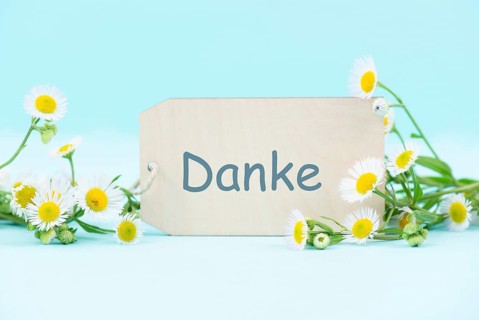 Thanks card surrounded by flowers, german language, being thankful, support, help and charity