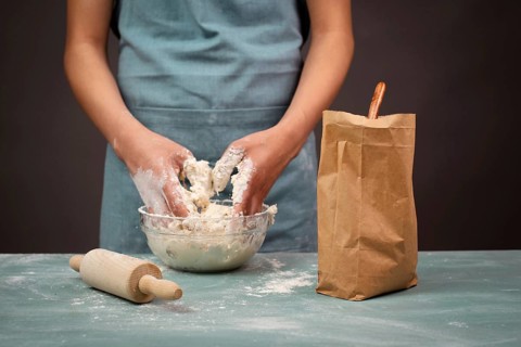 Baker kneading dough for artisan bread or pizza with his hands, prepare ingredients for food,