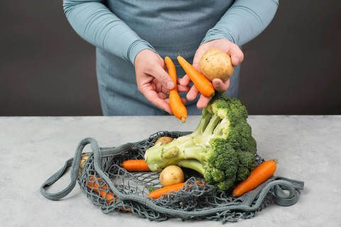 Mesh bag with vegetables, shopping grocery, healthy food ingredients, potato, broccoli and carrots,