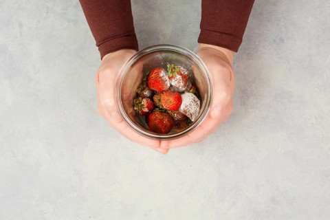 Moldy strawberry fruits with spot fungus in a jar, rotten strawberries, decomposition of the food