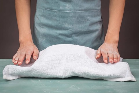 Fresh yeast dough, baker covers bowl with towel for fermentation, bread or pizza, prepare