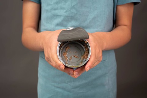 Open tin can with preserved food, empty box of tuna fish, processed ingredients, feeding a pet