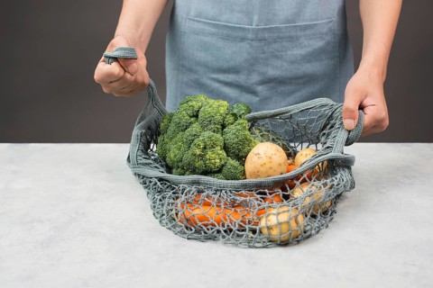 Mesh bag with vegetables, shopping grocery, healthy food ingredients, potato, broccoli and carrots,