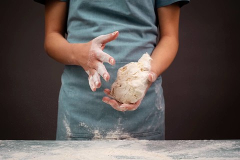 Baker kneading dough for pizza or artisan bread with his hands, prepare ingredients for food,