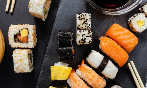 Black slate tray of assorted sushi and rolls