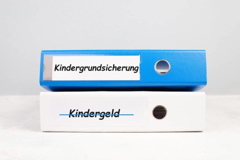 Basic child benefit stands in german language on the file folder, new payment regulation for family