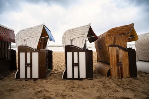 Roofed wicker beach chairs at the baltic sea beach, coast at the island of Usedom in Germany, storm